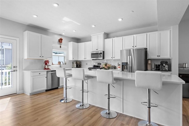 4012 Crown Dr, South Park, PA 15129 - kitchen with stainless steel appliances, a breakfast bar area, decorative backsplash, white cabinetry, and recessed lighting
