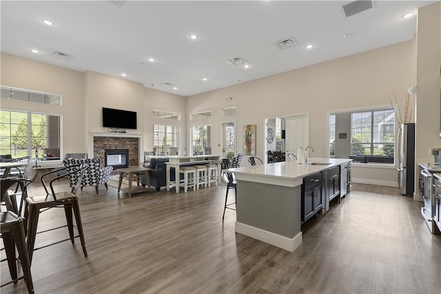 4012 Crown Dr, South Park, PA 15129 - kitchen featuring a fireplace, freestanding refrigerator, a towering ceiling, a kitchen bar, and plenty of natural light