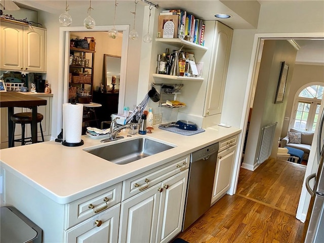 kitchen featuring stainless steel dishwasher, a sink, light wood-style flooring, open shelves, and light countertops
