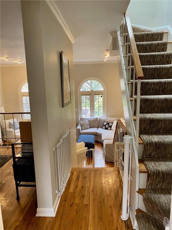 stairway featuring ornamental molding, wood-type flooring, and radiator