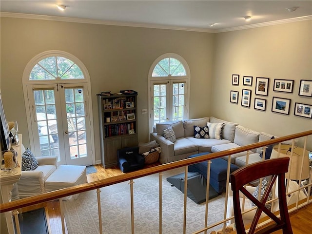 living area featuring french doors, healthy amount of natural light, wood finished floors, and ornamental molding
