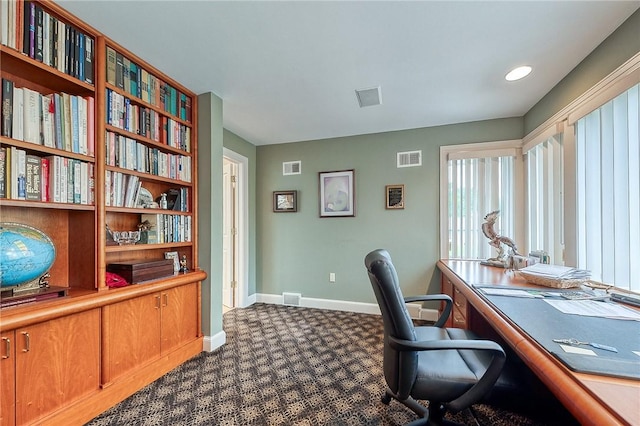 office with baseboards and dark carpet