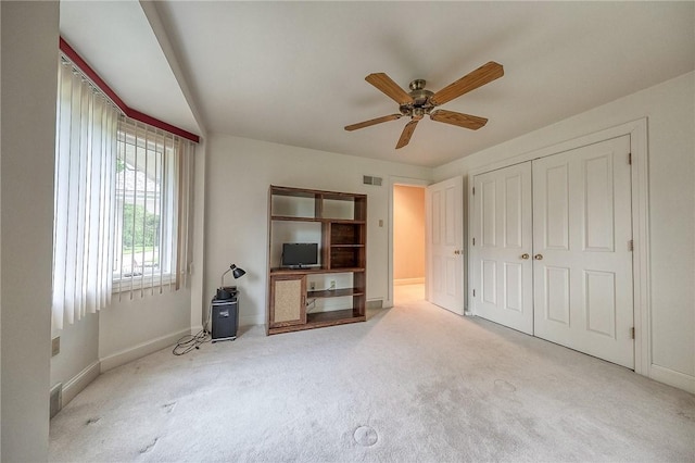 living area with carpet, baseboards, and a ceiling fan