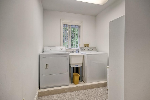 washroom with washer and dryer and baseboards