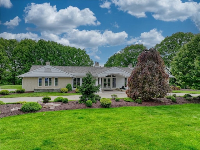 view of front of house featuring french doors, a front lawn, and a chimney