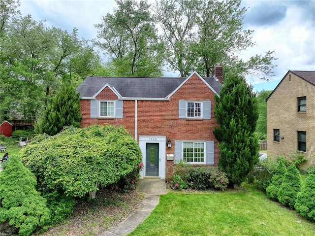 1593 Riverside Dr, Penn Hills, PA 15147 - view of front facade with brick siding, a chimney, and a front lawn