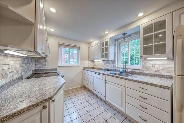 1593 Riverside Dr, Penn Hills, PA 15147 - kitchen featuring a sink, white dishwasher, glass insert cabinets, white cabinets, and tasteful backsplash