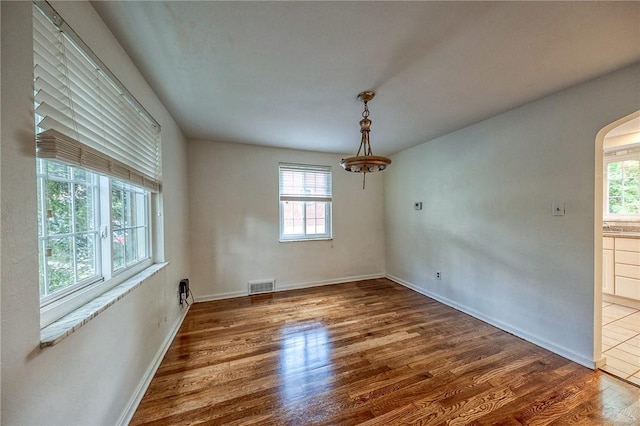 1593 Riverside Dr, Penn Hills, PA 15147 - unfurnished dining area featuring plenty of natural light, wood finished floors, arched walkways, and baseboards