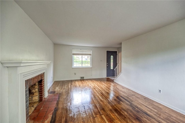 1593 Riverside Dr, Penn Hills, PA 15147 - unfurnished living room with a brick fireplace, wood finished floors, baseboards, and stairs