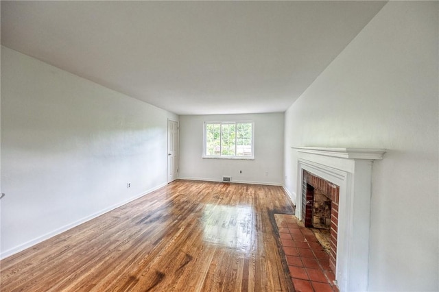 1593 Riverside Dr, Penn Hills, PA 15147 - unfurnished living room with wood finished floors, a brick fireplace, and baseboards