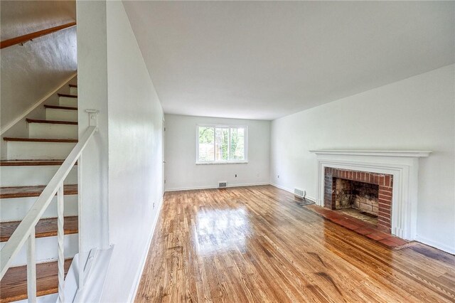 1593 Riverside Dr, Penn Hills, PA 15147 - unfurnished living room with wood finished floors, a fireplace, stairs, and baseboards
