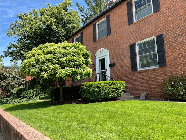 view of front of home with a front yard and brick siding