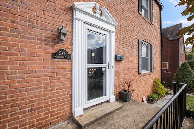 doorway to property with brick siding