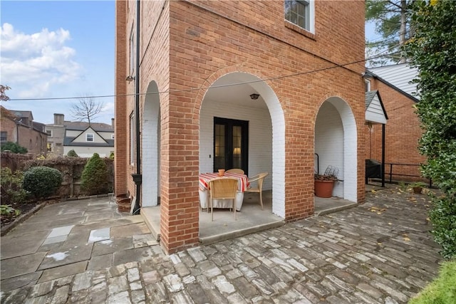 view of patio featuring french doors and fence