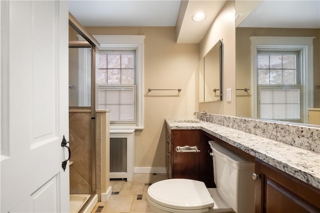 full bath featuring vanity, a shower stall, baseboards, and plenty of natural light