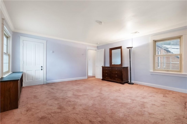 unfurnished bedroom featuring crown molding, multiple windows, baseboards, and carpet floors
