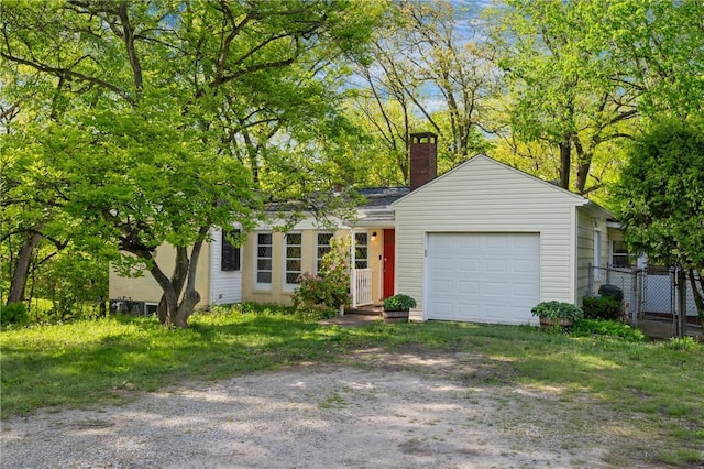view of front of property featuring a chimney, dirt driveway, a garage, fence, and a gate