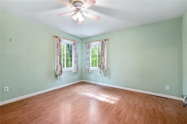 unfurnished room with wood finished floors, baseboards, and ceiling fan