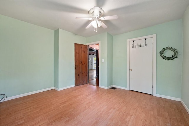 unfurnished bedroom featuring light wood-style flooring, baseboards, a ceiling fan, and a closet