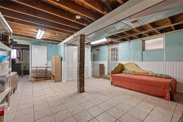 basement with wainscoting and tile patterned floors