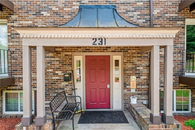 property entrance with brick siding and covered porch
