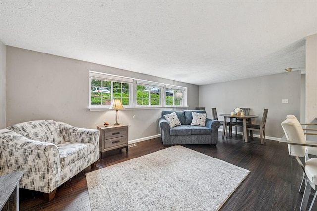 living room with baseboards, a textured ceiling, and hardwood / wood-style flooring