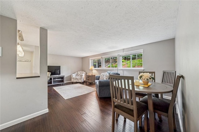 dining room with baseboards, hardwood / wood-style flooring, and a textured ceiling