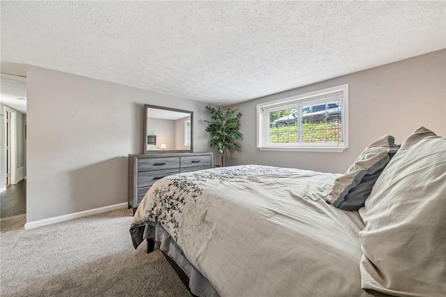 carpeted bedroom featuring a textured ceiling and baseboards