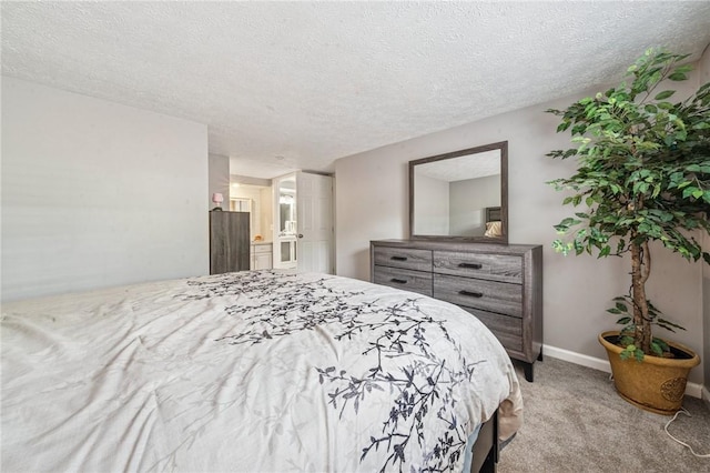 bedroom featuring carpet flooring, a textured ceiling, baseboards, and connected bathroom