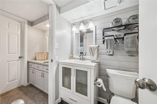 bathroom with vanity, toilet, and a textured ceiling