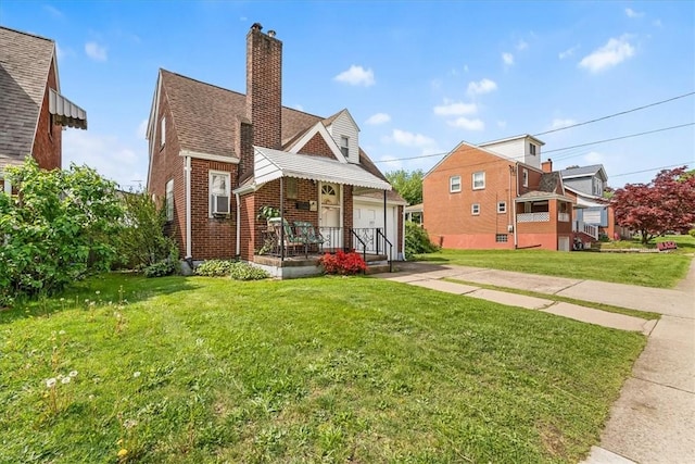 view of front facade featuring brick siding, a chimney, a front lawn, and a shingled roof