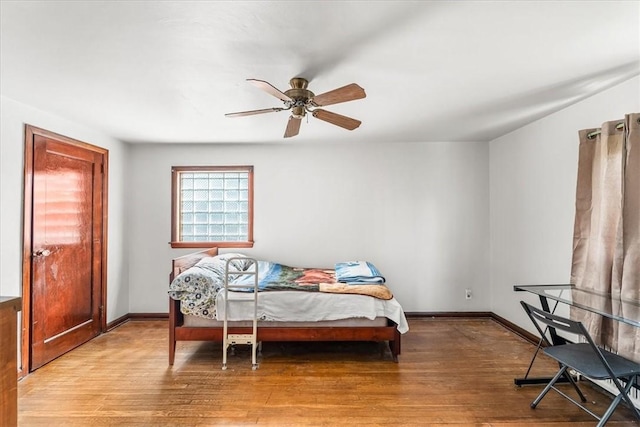 bedroom with wood finished floors, baseboards, and ceiling fan