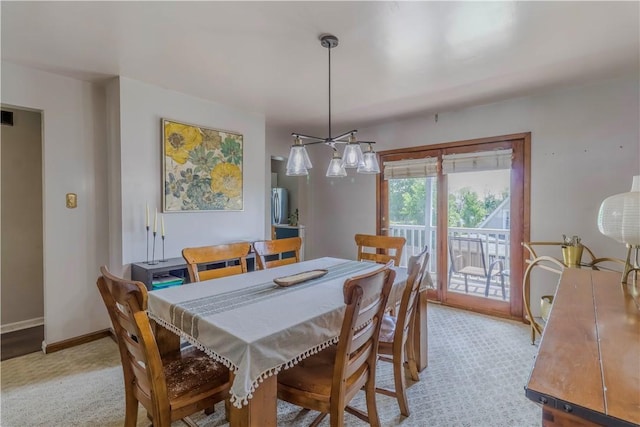 dining area featuring baseboards, a chandelier, and light carpet