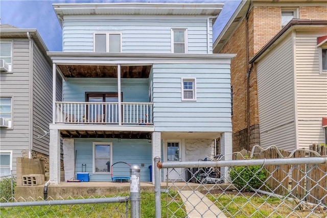 back of property with a balcony and fence