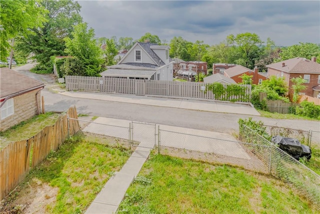fenced yard featuring a gate and a residential view