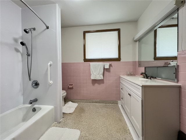 bathroom with a wainscoted wall, tile walls, vanity, toilet, and shower / tub combination