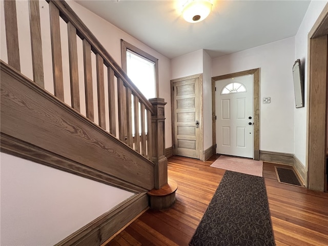 entrance foyer with stairs, light wood-style floors, and baseboards