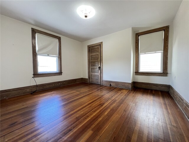 empty room featuring hardwood / wood-style floors and baseboards