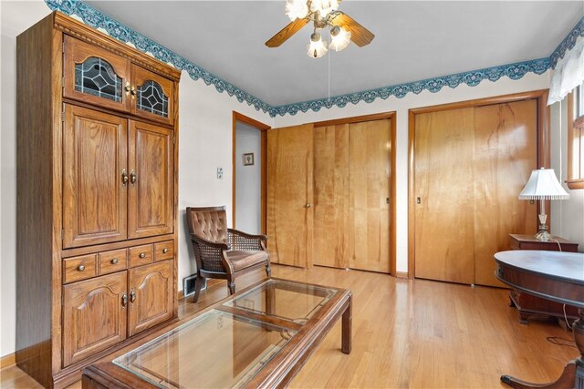 sitting room featuring light wood finished floors and a ceiling fan