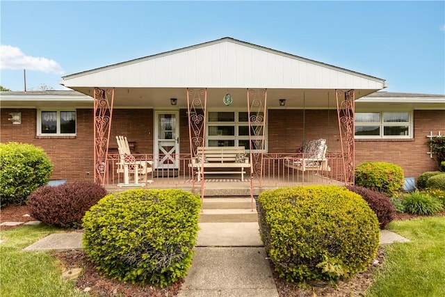view of front of house with covered porch and brick siding