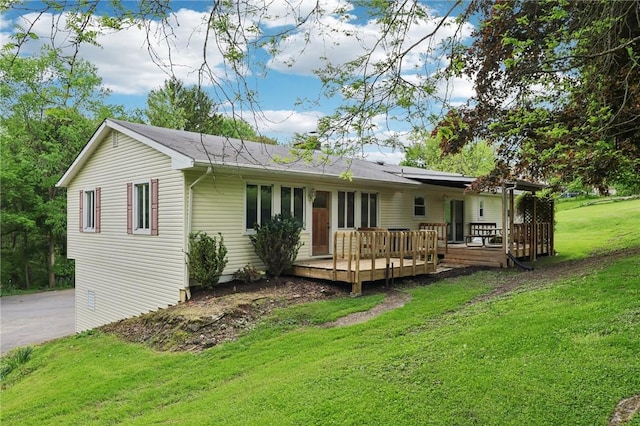back of property featuring a lawn and a deck