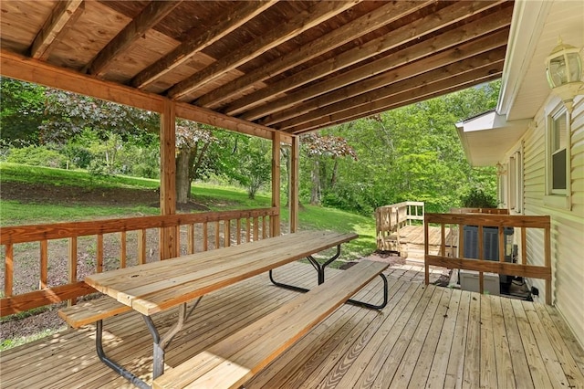 deck with outdoor dining area and a yard