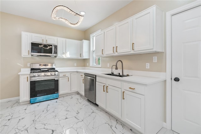 kitchen with appliances with stainless steel finishes, a sink, white cabinetry, light countertops, and light marble finish flooring