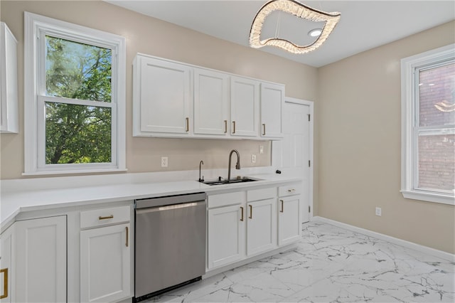 kitchen featuring stainless steel dishwasher, a sink, light marble finish floors, and plenty of natural light