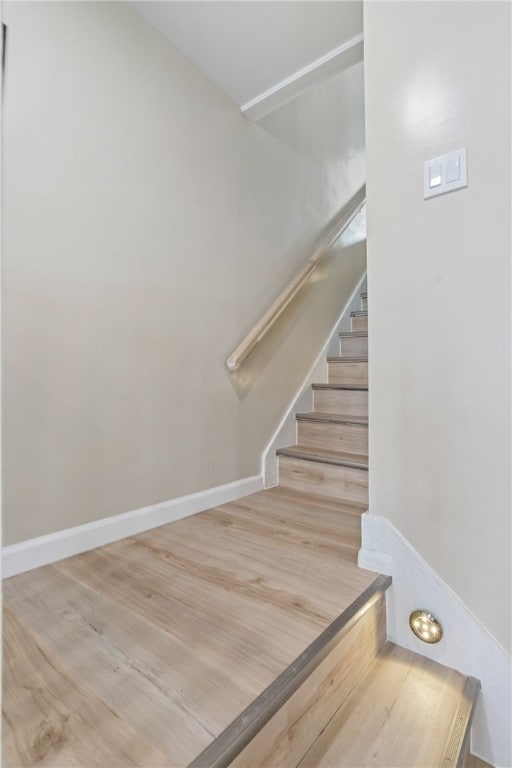 stairway featuring wood finished floors and baseboards