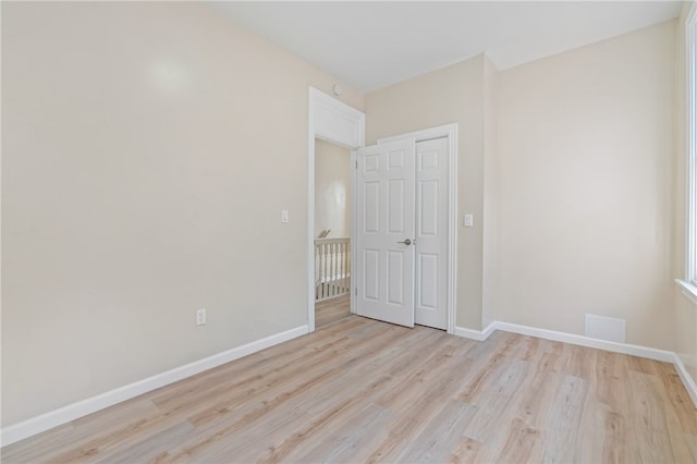 unfurnished bedroom featuring light wood-style flooring and baseboards
