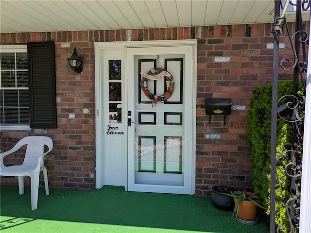 property entrance featuring brick siding
