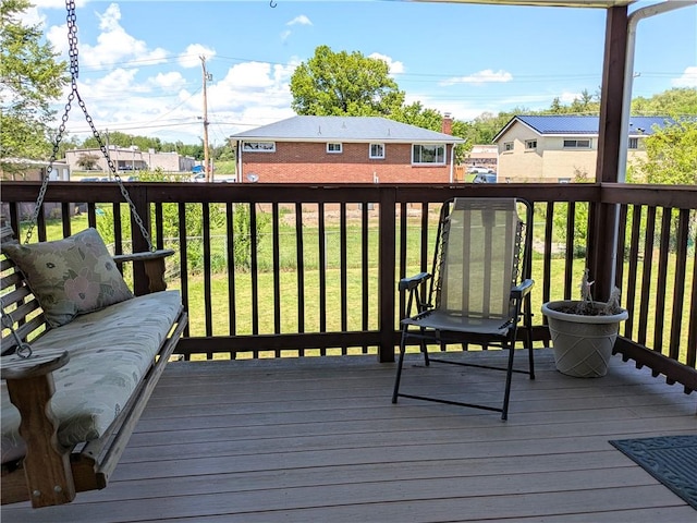 wooden deck featuring a lawn and a residential view