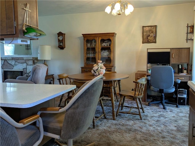 carpeted home office with a fireplace and a chandelier