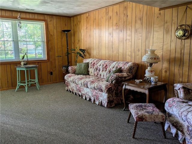 carpeted living area featuring wood walls